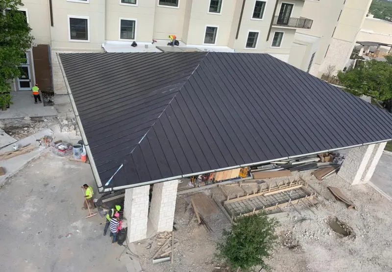 Metal roofing installation team working on a commercial building in Schoolcraft